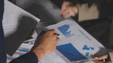 İş adamı hesap makinesi ve dizüstü bilgisayarla finansal tabloları analiz ediyor.