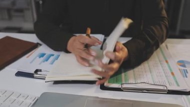 İşadamı dizüstü bilgisayar üzerinde çalışıyor ve çizelgeleri analiz ediyor.