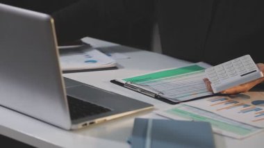 Finans çizelgeleri ve grafikleri olan dizüstü bilgisayar kullanan bir iş kadını.