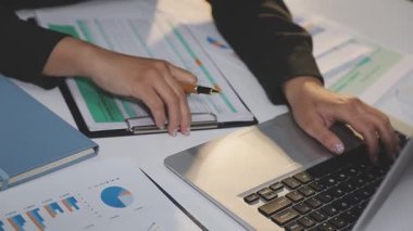 İş adamı ofis masasında dizüstü bilgisayarla finansal verileri analiz ediyor..