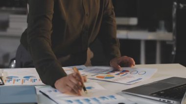 İş adamı masadaki hesap makinesiyle verileri analiz ediyor..