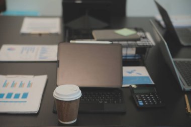 Açık bir finans bürosundaki masada dizüstü bilgisayar..