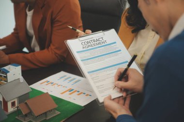 Mimarlar ve iş adamları, emlak yatırımları ve konut geliştirme projesi için zemin planı modifikasyonunu tartışıp fikir alışverişinde bulunuyorlar.