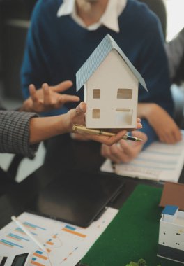 Mimarlar ve iş adamları, emlak yatırımları ve konut geliştirme projesi için zemin planı modifikasyonunu tartışıp fikir alışverişinde bulunuyorlar.