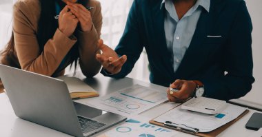 İş ekibi ile yeni başlangıç planı ve tartışma için proje bilgilerini dizüstü bilgisayar ve dijital tablet ile mali strateji bir modern iş salonda çalışıyor.