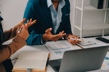 İş ekibi ile yeni başlangıç planı ve tartışma için proje bilgilerini dizüstü bilgisayar ve dijital tablet ile mali strateji bir modern iş salonda çalışıyor.