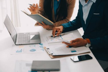 İş ekibi ile yeni başlangıç planı ve tartışma için proje bilgilerini dizüstü bilgisayar ve dijital tablet ile mali strateji bir modern iş salonda çalışıyor.