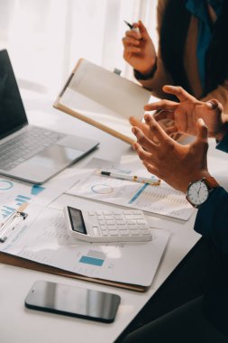 İş ekibi ile yeni başlangıç planı ve tartışma için proje bilgilerini dizüstü bilgisayar ve dijital tablet ile mali strateji bir modern iş salonda çalışıyor.