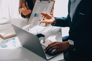 İş ekibi ile yeni başlangıç planı ve tartışma için proje bilgilerini dizüstü bilgisayar ve dijital tablet ile mali strateji bir modern iş salonda çalışıyor.