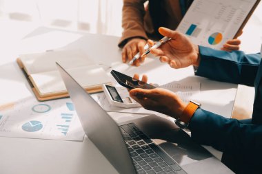 İş ekibi ile yeni başlangıç planı ve tartışma için proje bilgilerini dizüstü bilgisayar ve dijital tablet ile mali strateji bir modern iş salonda çalışıyor.