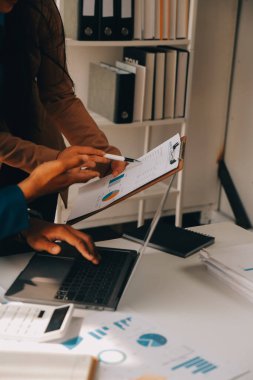 İş ekibi ile yeni başlangıç planı ve tartışma için proje bilgilerini dizüstü bilgisayar ve dijital tablet ile mali strateji bir modern iş salonda çalışıyor.