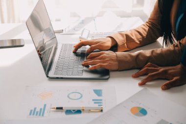 İş ekibi ile yeni başlangıç planı ve tartışma için proje bilgilerini dizüstü bilgisayar ve dijital tablet ile mali strateji bir modern iş salonda çalışıyor.