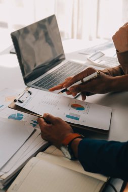 İş ekibi ile yeni başlangıç planı ve tartışma için proje bilgilerini dizüstü bilgisayar ve dijital tablet ile mali strateji bir modern iş salonda çalışıyor.