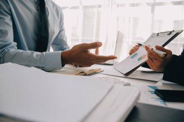 İş ekibi ile yeni başlangıç planı ve tartışma için proje bilgilerini dizüstü bilgisayar ve dijital tablet ile mali strateji bir modern iş salonda çalışıyor.