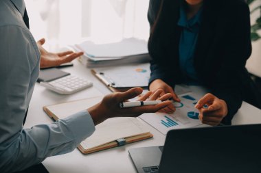 İş ekibi ile yeni başlangıç planı ve tartışma için proje bilgilerini dizüstü bilgisayar ve dijital tablet ile mali strateji bir modern iş salonda çalışıyor.