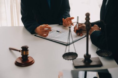 Adalet ve hukuk kavramı. Hukuk Müşaviri tokmak ve yasal hukuk veya yasal ile imzalanmış bir sözleşme istemciye sunar arka planda hukuk firmasında takım toplantısı