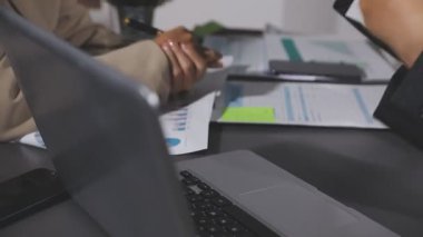 Çalışma masasında dizüstü bilgisayar ve belgeyle çalışan işadamı.