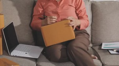 Genç adam dizüstü bilgisayar ve belgelerle çalışıyor.