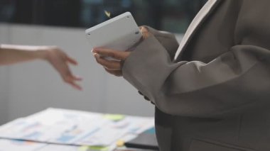 Dijital tablet tutan işadamlarına yakın çekim yapın ve ofis masasında otururken akıllı telefonunu kullanın..