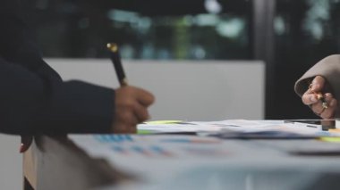 İş adamları iş planı yapmak için finansal grafikleri analiz ediyorlar.