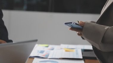 İşadamları not alıyor ve ofiste yeni bir iş planı tartışıyorlar..