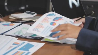 Kağıda rapor yazmak için elinde kalem tutan bir iş adamı..