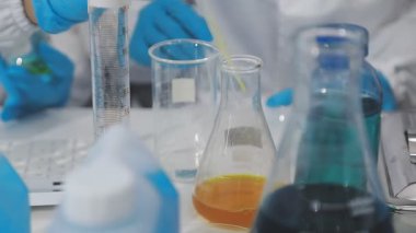 Bir tüp sıvı tutan laboratuvar asistanı..