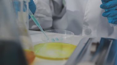 Laboratuvar asistanı cam şişeyi laboratuvarda tutuyor.