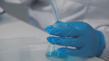 Yakın çekim - cam matara tutan bilim adamı elleri