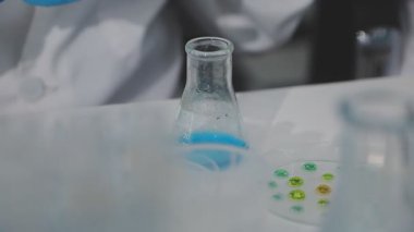 Laboratuvardaki laboratuvar asistanı. Bilim adamı elinde sıvı olan bir test tüpü tutuyor..