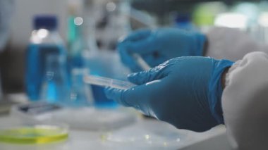 Laboratuvardaki bilim adamı test tüpüyle çalışıyor.