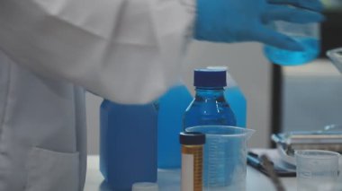 Yakın çekim - test tüplerini sıvı ile tutan bilim adamlarının elleri.