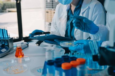 Araştırma ya da geliştirme için laboratuardaki insanlarla işbirliği, tablet ya da bilim. Tıbbi araştırma ve planlama için klinik deneyde bilim adamlarıyla buluşlar, teknolojiler ve mikroskop