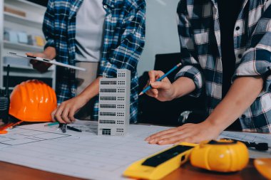 Modellik ve mühendislik araçları, inşaat konsepti ve çalışma sahasındaki proje ortağı ile çalışma planı toplantısı üzerine çalışan mühendis inşaat ve yapı kavramı.