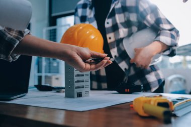 Modellik ve mühendislik araçları, inşaat konsepti ve çalışma sahasındaki proje ortağı ile çalışma planı toplantısı üzerine çalışan mühendis inşaat ve yapı kavramı.