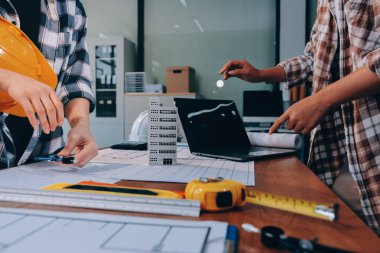 Modellik ve mühendislik araçları, inşaat konsepti ve çalışma sahasındaki proje ortağı ile çalışma planı toplantısı üzerine çalışan mühendis inşaat ve yapı kavramı.