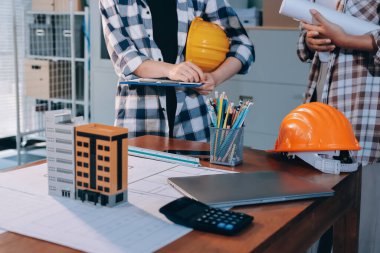 Modellik ve mühendislik araçları, inşaat konsepti ve çalışma sahasındaki proje ortağı ile çalışma planı toplantısı üzerine çalışan mühendis inşaat ve yapı kavramı.