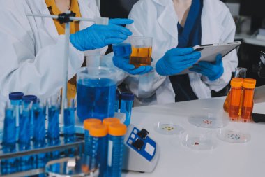 Araştırma ya da geliştirme için laboratuardaki insanlarla işbirliği, tablet ya da bilim. Tıbbi araştırma ve planlama için klinik deneyde bilim adamlarıyla buluşlar, teknolojiler ve mikroskop