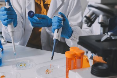 Araştırma ya da geliştirme için laboratuardaki insanlarla işbirliği, tablet ya da bilim. Tıbbi araştırma ve planlama için klinik deneyde bilim adamlarıyla buluşlar, teknolojiler ve mikroskop