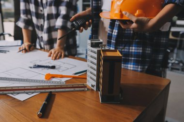 Modellik ve mühendislik araçları, inşaat konsepti ve çalışma sahasındaki proje ortağı ile çalışma planı toplantısı üzerine çalışan mühendis inşaat ve yapı kavramı.