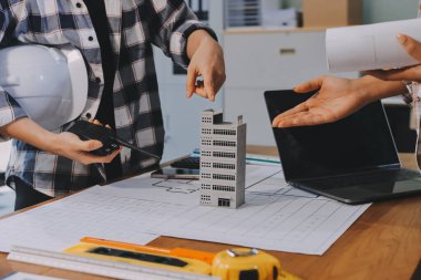 Modellik ve mühendislik araçları, inşaat konsepti ve çalışma sahasındaki proje ortağı ile çalışma planı toplantısı üzerine çalışan mühendis inşaat ve yapı kavramı.