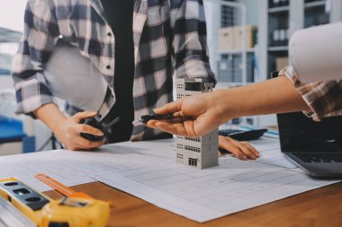 Modellik ve mühendislik araçları, inşaat konsepti ve çalışma sahasındaki proje ortağı ile çalışma planı toplantısı üzerine çalışan mühendis inşaat ve yapı kavramı.