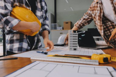 Modellik ve mühendislik araçları, inşaat konsepti ve çalışma sahasındaki proje ortağı ile çalışma planı toplantısı üzerine çalışan mühendis inşaat ve yapı kavramı.