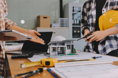 Modellik ve mühendislik araçları, inşaat konsepti ve çalışma sahasındaki proje ortağı ile çalışma planı toplantısı üzerine çalışan mühendis inşaat ve yapı kavramı.