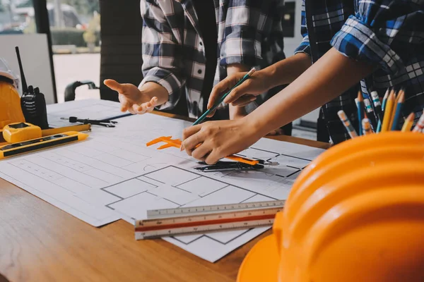 Modellik ve mühendislik araçları, inşaat konsepti ve çalışma sahasındaki proje ortağı ile çalışma planı toplantısı üzerine çalışan mühendis inşaat ve yapı kavramı.