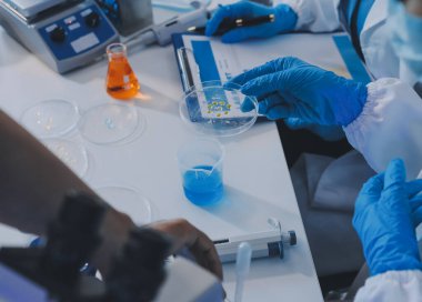 Araştırma ya da geliştirme için laboratuardaki insanlarla işbirliği, tablet ya da bilim. Tıbbi araştırma ve planlama için klinik deneyde bilim adamlarıyla buluşlar, teknolojiler ve mikroskop