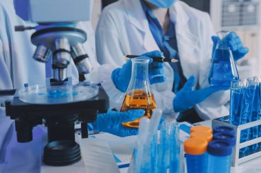 Araştırma ya da geliştirme için laboratuardaki insanlarla işbirliği, tablet ya da bilim. Tıbbi araştırma ve planlama için klinik deneyde bilim adamlarıyla buluşlar, teknolojiler ve mikroskop