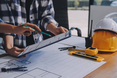 Modellik ve mühendislik araçları, inşaat konsepti ve çalışma sahasındaki proje ortağı ile çalışma planı toplantısı üzerine çalışan mühendis inşaat ve yapı kavramı.