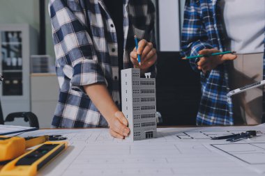 Modellik ve mühendislik araçları, inşaat konsepti ve çalışma sahasındaki proje ortağı ile çalışma planı toplantısı üzerine çalışan mühendis inşaat ve yapı kavramı.