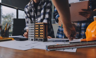 Modellik ve mühendislik araçları, inşaat konsepti ve çalışma sahasındaki proje ortağı ile çalışma planı toplantısı üzerine çalışan mühendis inşaat ve yapı kavramı.